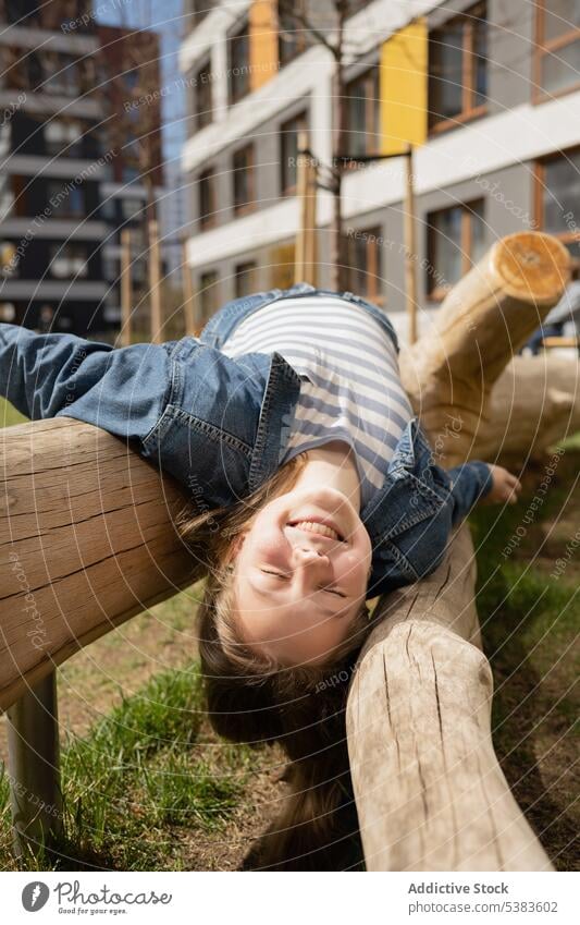 Cheerful teen girl lying on log in park enjoy playful summer happy carefree smile chill teenager young weekend delight cheerful casual having fun city positive