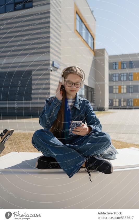 Trendy teen girl enjoying music on bench in city headphones listen leisure carefree teenage using modern style trendy summer teenager young urban sit bag