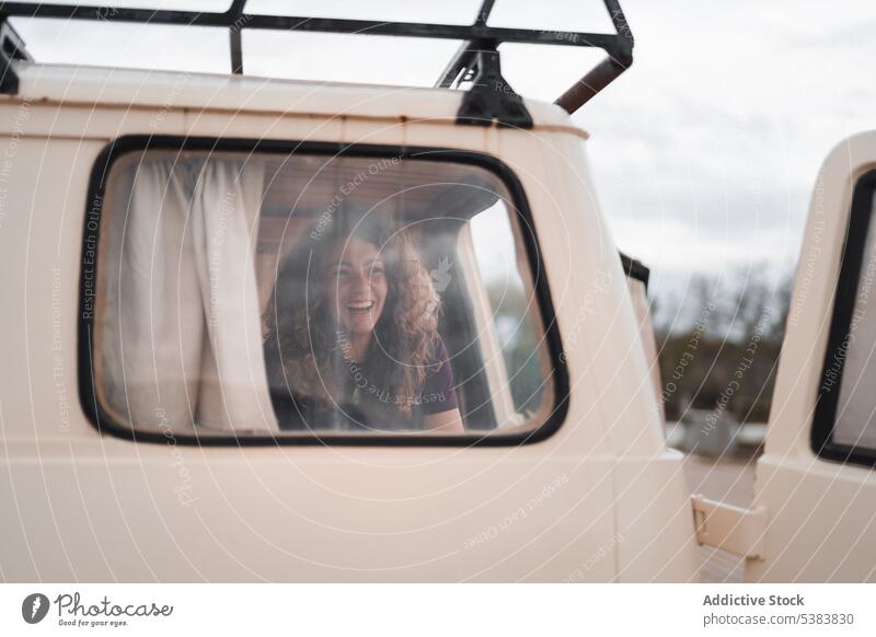 Smiling young woman sitting in parked van with opened back door window smile positive glad summer happy cheerful female vehicle journey dreamy inside transport