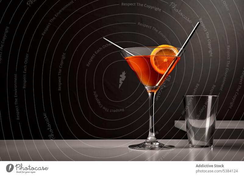 Generative AI illustration of glass with alcohol drink placed on grey against table near empty glass against black background with straw cocktail beverage booze