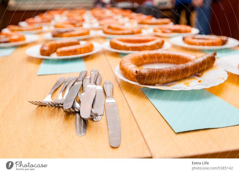 Pile of flatware in front of grilled and fresh handmade sausages on white plate arranged for sausage tournament Arranged Assess Baked Bratwurst Bunch Caloric