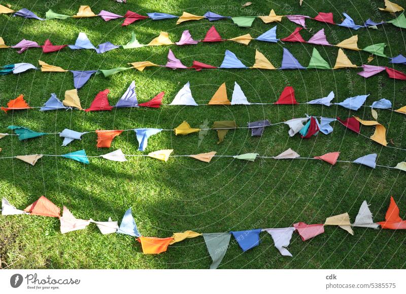Colorful: the homemade pennant garland from the summer festival dries in the sun on the lawn after the rain. Paper chain flag Decoration Feasts & Celebrations