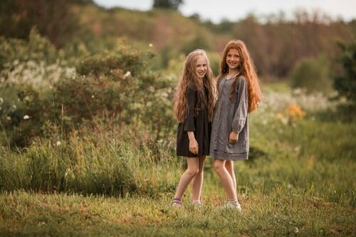 Two friends collect flowers in the field Red-haired long hair Curly Agriculture Love of nature To go for a walk sensation Contentment Sunlight