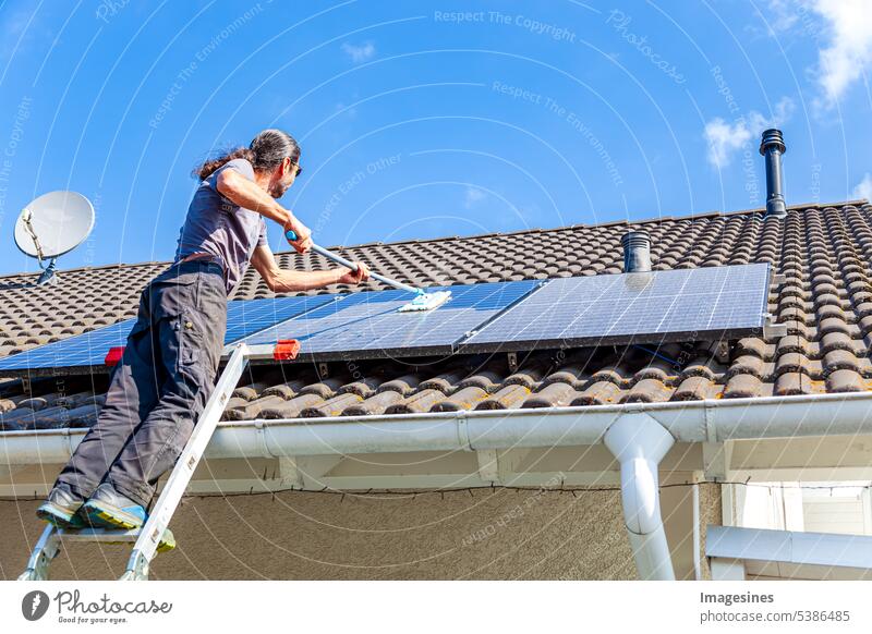 balcony power plant cleaning with mop Man Cleaning solar collectors solar modules Water Close-up Roof sunny Sky Mop Wash solar panel Summer Holiday season Day