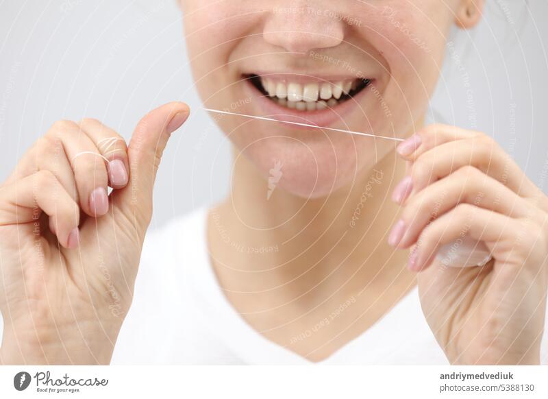 Oral hygiene and health care. Smiling woman use dental floss white healthy teeth. oral women mouth clean tooth young face smile fresh girl hand happy healthcare