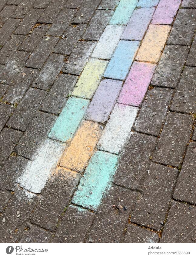 Strip with colorful paving stones crosses the gray sidewalk Paving stone off Chalk variegated pastel Footpath Places Sidewalk Structures and shapes Pattern