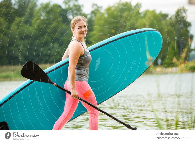 Young athletic woman paddling along the river standing on the sup board. walking with board active activity adventure attractive beach beautiful boarding