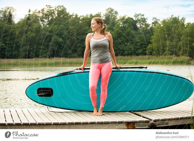 Young athletic woman paddling along the river standing on the sup board. Standing on deck with board active activity adventure attractive beach beautiful
