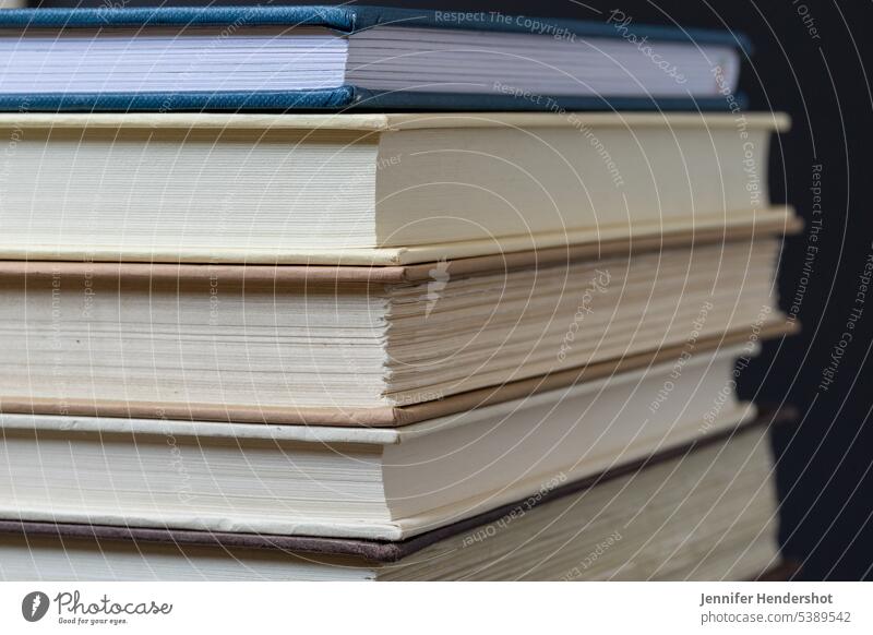 Angular macro photo of stack of hardcover books book stack close-up copy space library macro photography natural light reading horizontal hard cover education