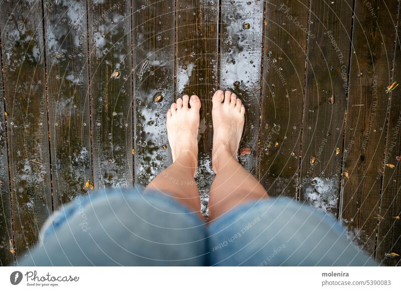 Person legs standing on wet wooden floor of patio barefoot rain drop house deck outside water backyard raindrop terrace outdoor person
