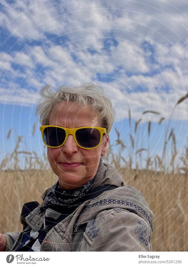Blonde woman with yellow sunglasses in cornfield Woman portrait Feminine Human being Hair and hairstyles pretty Face Looking 18 - 30 years Face of a woman