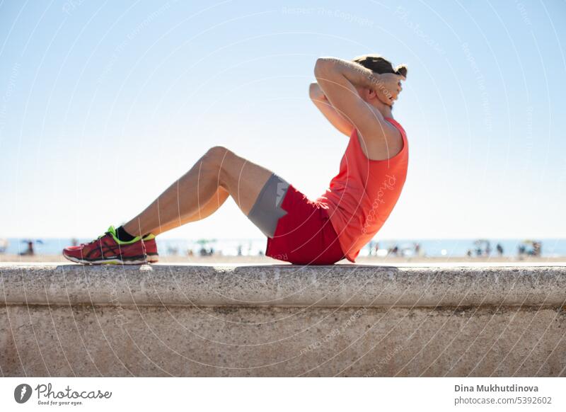 Unrecognizable person in red fitness outfit doing exercise on the beach on a sunny day. Outdoor workout. active activity adult athlete body caucasian city
