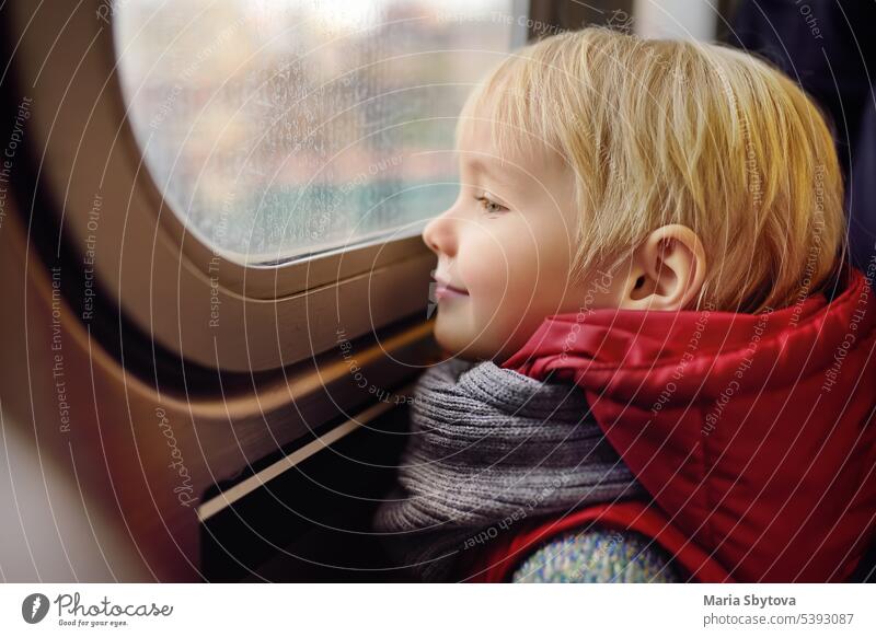Little boy looks out the window of the car in the subway in New York, USA. child metro train usa doors new york passenger city metropolitan american commuter