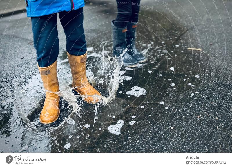 Endurance | Jumping in puddles Puddle children Rubber boots Wet Inject Asphalt Exterior shot Rain Playing Infancy Weather Bad weather Water Joy Autumn Happiness