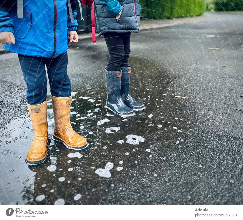 Two children standing in puddle with rubber boots Puddle Rubber boots Wet Asphalt Exterior shot Rain Playing Infancy Weather Bad weather Water Joy Autumn