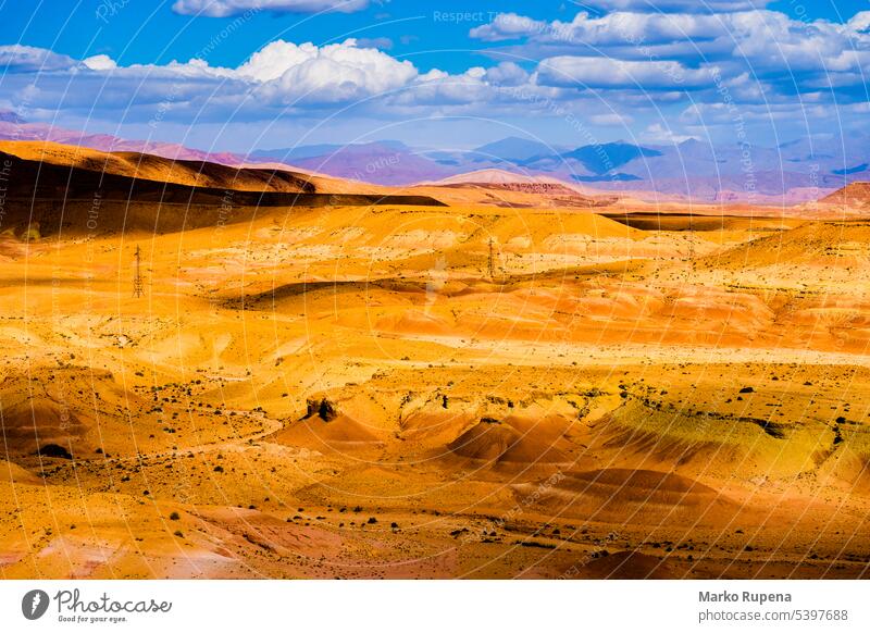 Picturesque landscape with orange sand dunes and mountains in Sahara desert with bright blue sky and clouds in Morocco sahara hills geology nature yellow travel