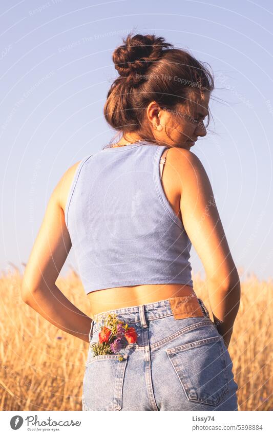Girl standing on the edge of the field with a bouquet of flowers in her pocket Nature Field Margin of a field Summer Grain field naturally golden light Bouquet