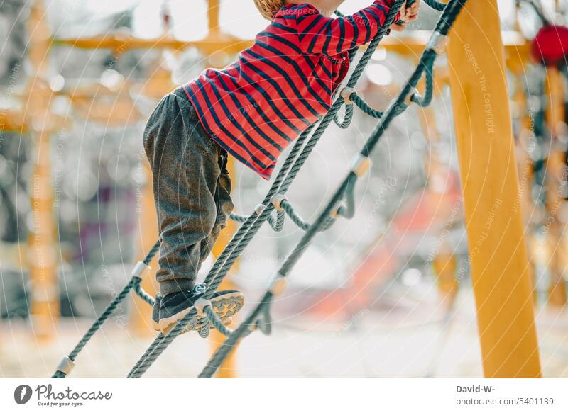 Child climbs on the playground Climbing Playground climbing scaffold Playing fun courageous explore Boy (child) max climb