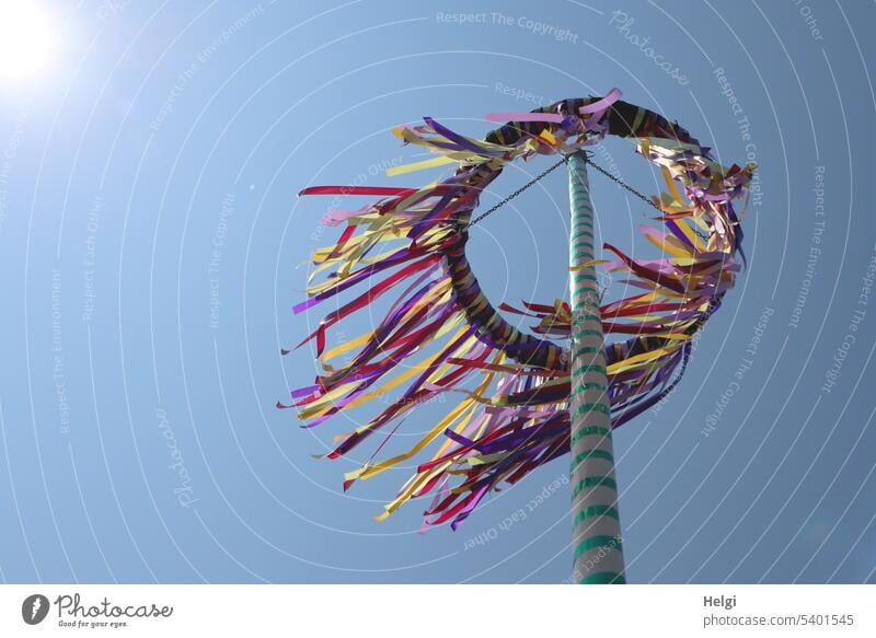 Maypole with waving ribbons in sunlight against blue sky May tree Wreath colorful ribbons customs Spring Feasts & Celebrations Exterior shot Decoration
