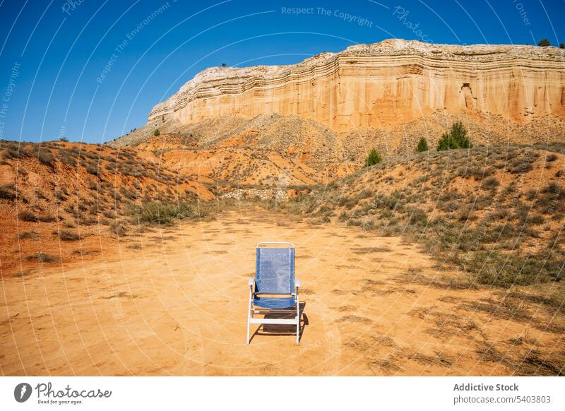 Empty folding chair in desert terrain on sunny day fabric chair mountain hike trip rocky cliff canyon landscape rojo teruel nature empty picturesque scenic