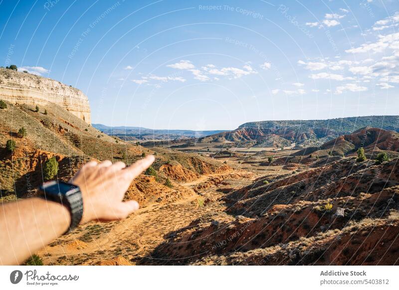 Top view traveler pointing to picturesque landscape mountain anonymous canyon rocky nature valley adventure tourism explore rojo teruel journey hand range trip