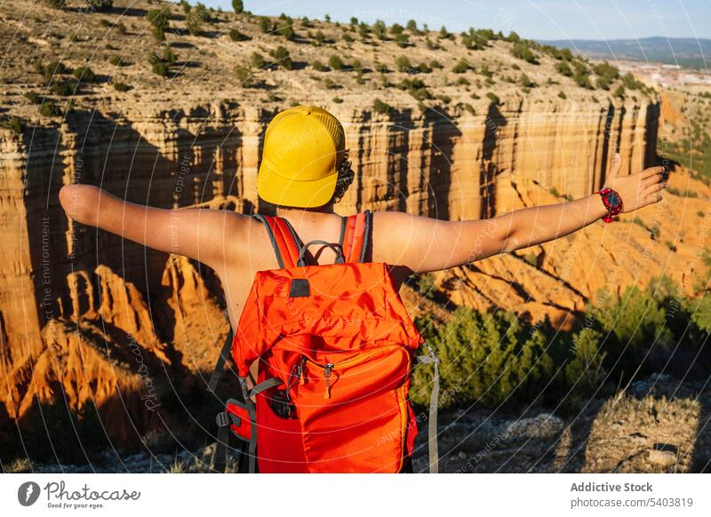 Unrecognizable traveler with backpack above majestic mountains man amputee shirtless freedom canyon cliff shadow male vacation casual rojo teruel adventure guy
