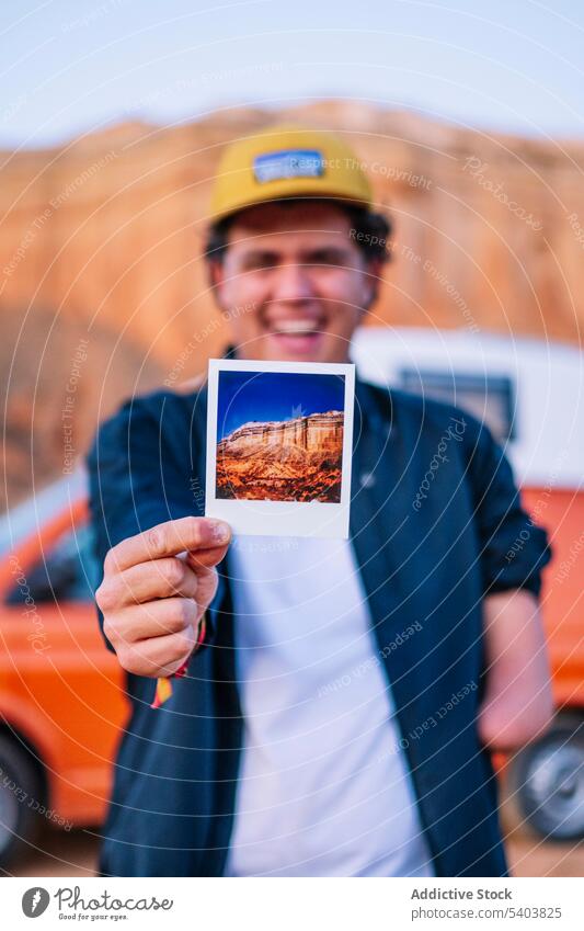 Blurred image of cheerful man holding picture mountain canyon photo instant landscape amputee memory moment rojo teruel spain nature travel male adventure
