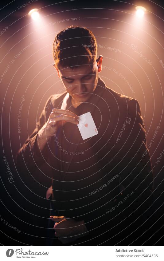 Man with ace of hearts man illusionist magic trick play card perform stage male magician conjuror abracadabra entertain leisure amusement circus show
