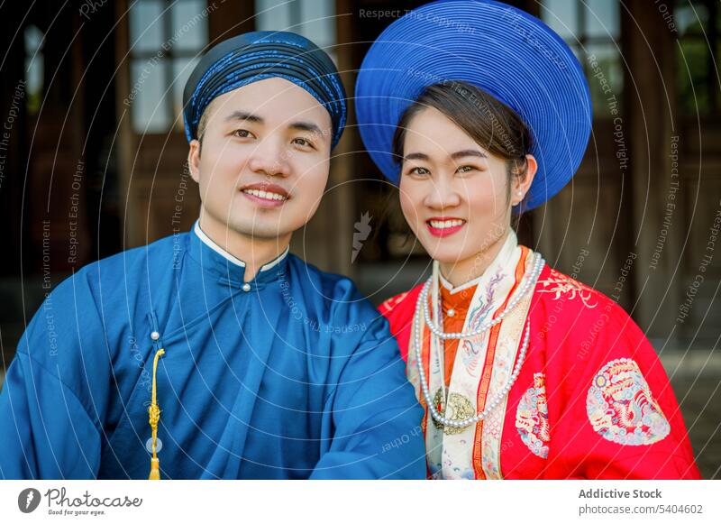 Happy Asian couple spending time together relationship portrait tradition gorgeous style clothes smile affection veranda authentic house terrace happy young