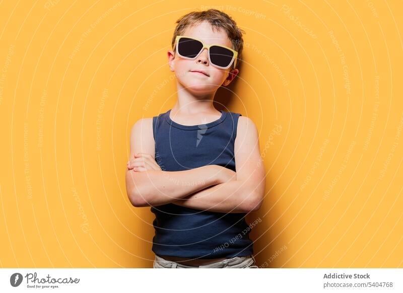 Stylish boy in sunglasses with crossed arms in studio style trendy portrait tank top arms crossed confident cool attitude youngster preteen child kid childhood