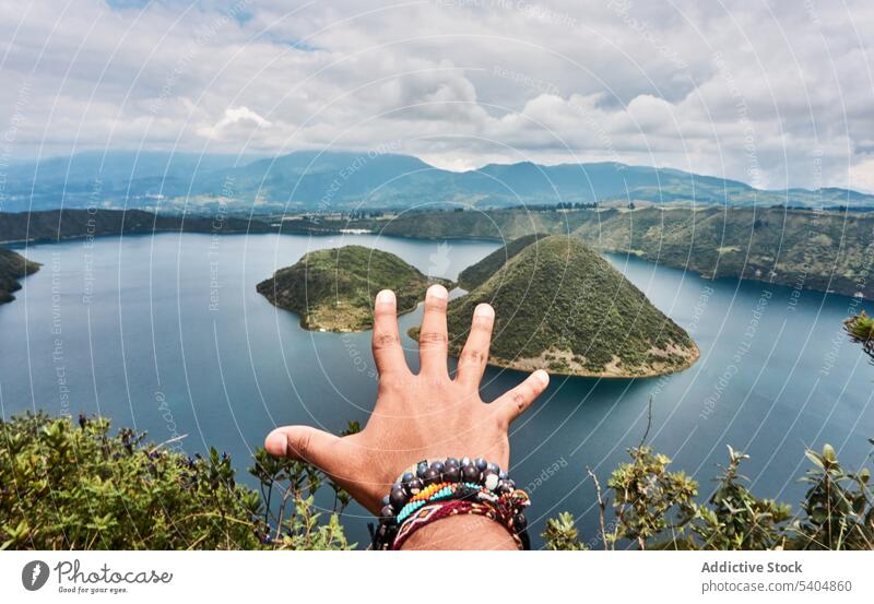 Unrecognizable person reaching to lake hand gesture finger nature picturesque bracelet show summer peace sea lagoon idyllic tranquil calm demonstrate sign