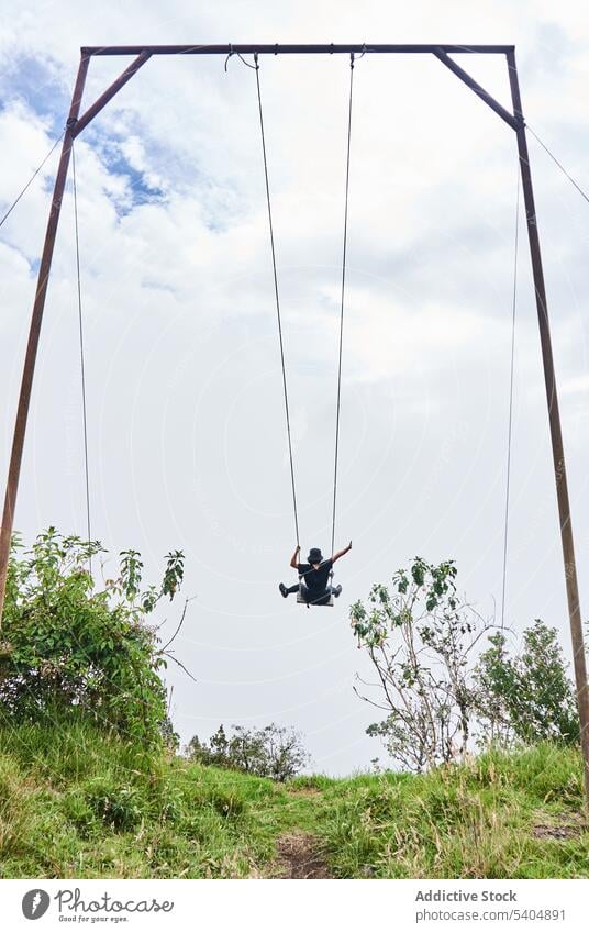 Anonymous person swinging on rope and enjoying amazing view of clouds and mountains summer adventure nature cloudy freedom tourism daylight vacation carefree
