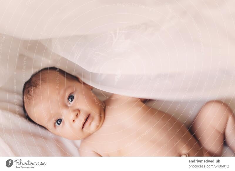 Soft picture of a beautiful baby laying on white bedding at home child cute girl happy little naked person boy caucasian infant kid small toddler childhood face