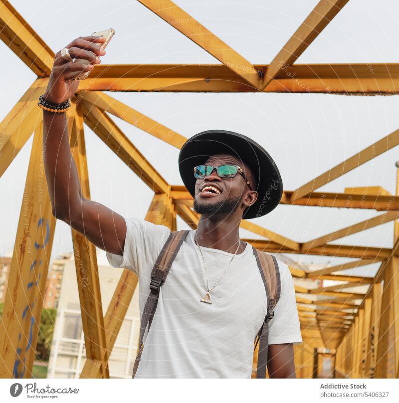 Stylish black man taking selfie on bridge style tourist smartphone cool street city self portrait male african american mobile handsome ethnic take photo memory
