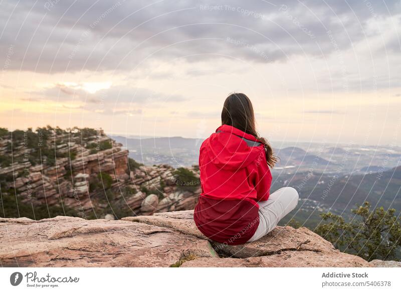 Anonymous female traveler resting on edge of mountain cliff woman tourist hiker trekking relax thoughtful el garbi viewpoint valencia spain nature highland
