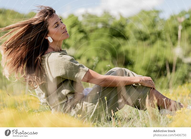 Dreamy woman with flowing hair resting on grassy meadow dreamy relax field thoughtful nature enjoy countryside female young peaceful eyes closed casual tranquil