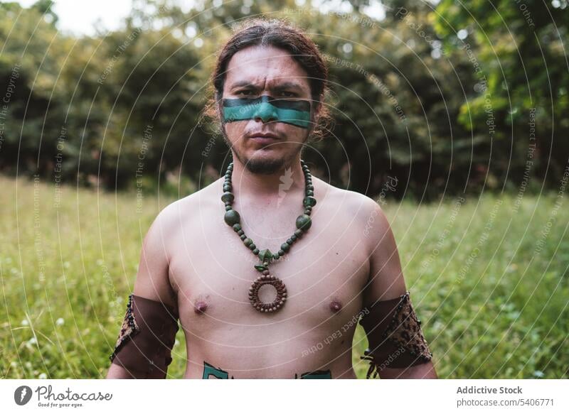 Mayan characterized man looking to the camera indigenous maya native mayan aztec tribes historical history warrior mexico vegetation lush green ulama warpaint
