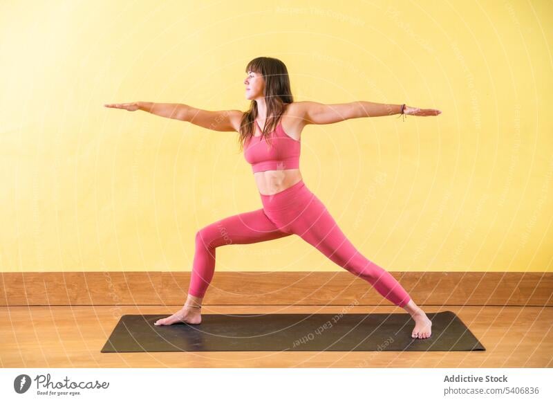 Slim woman doing Virabhadrasana A on yoga mat - a Royalty Free Stock Photo  from Photocase