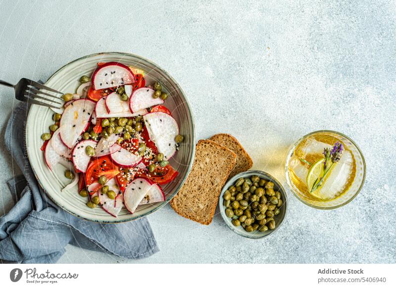 Vegetable salad with organic tomato and capers, lemonade and bread bowl canned capparis cuisine dinner eat food fresh glass green healthy ice lime lunch meal