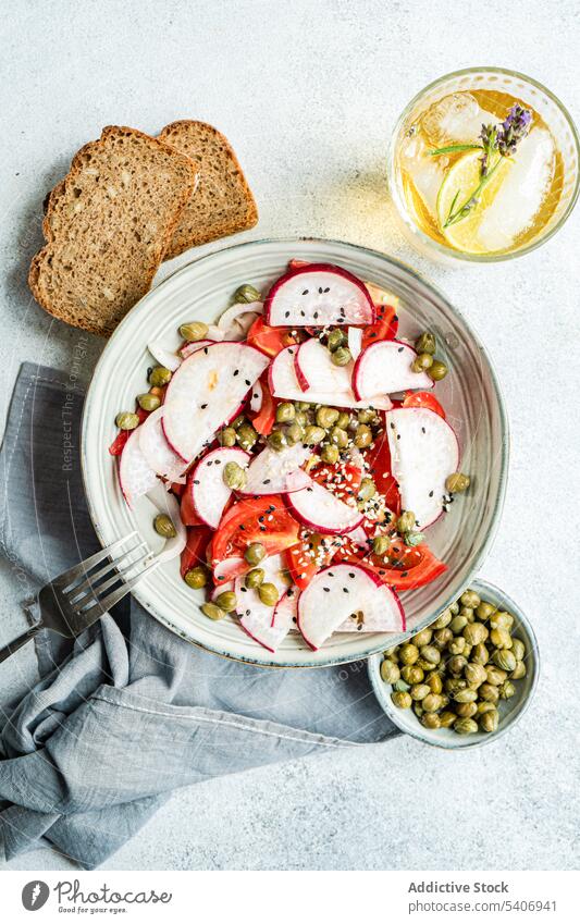 Vegetable salad with organic tomato and capers, lemonade and bread bowl canned capparis cuisine dinner eat food fresh glass green healthy ice lime lunch meal