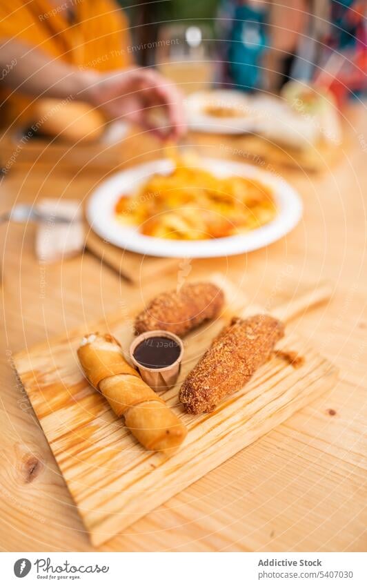 Delicious roll and croquettes on cutting board delicious serve sauce food table restaurant drink appetizing culinary fresh meal tasty gastronomy savory portion