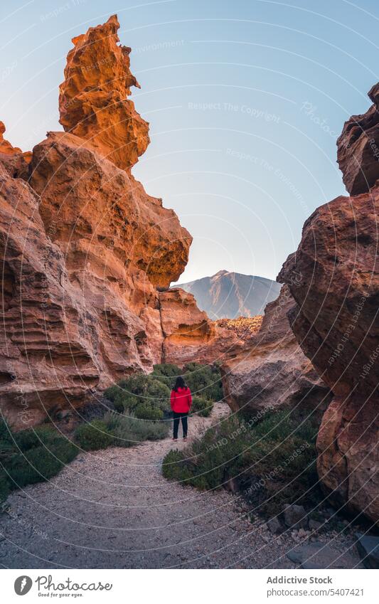Unrecognizable woman traveler standing on gravel path near volcanic formations tourist admire mountain nature landscape explore stone rock journey volcano
