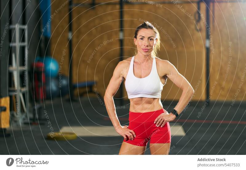 Smiling muscular sportswoman standing in gym confident body training appearance strong fitness smile adult top vitality motivation wellness determine healthy