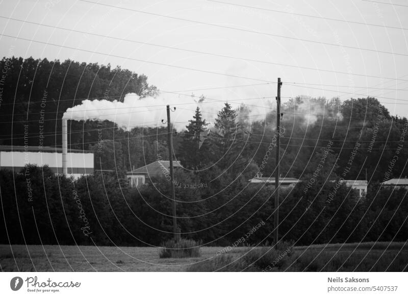 black and white industrial landscape. Electric power poles and wires in air, Smoke comes from chimney abstract architecture atmosphere background building