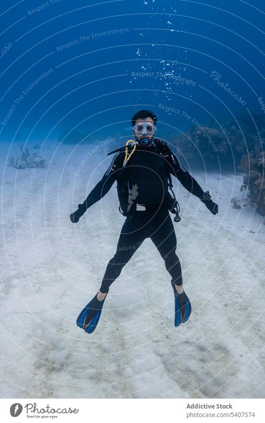 Male diver in diving suit and mask swimming underwater man explorer scuba deep bottom ocean cancun mexico america activity transparent clean clear bubble oxygen