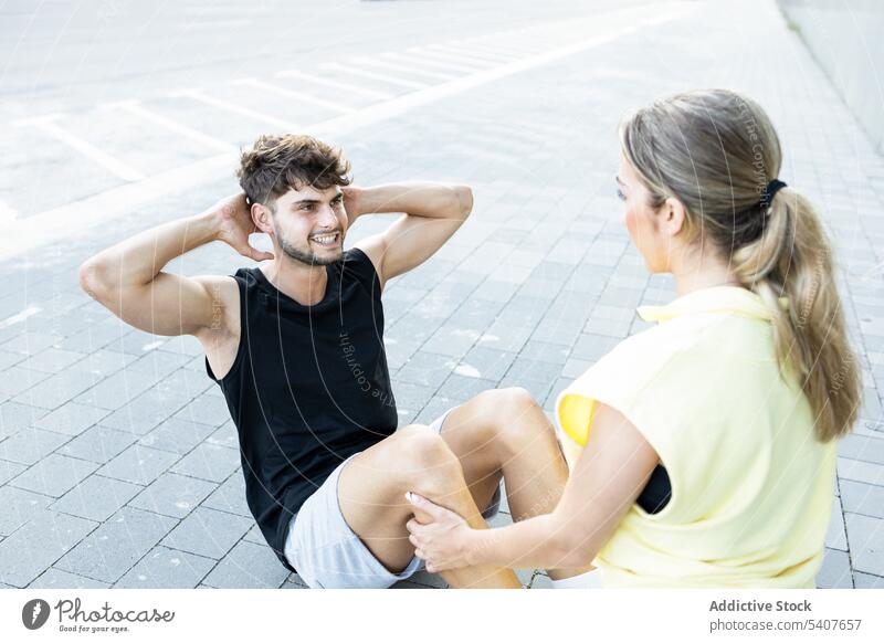 Happy couple in body fit exercise on street happy training together relationship love workout smile fitness pavement city lifestyle urban sport casual cheerful