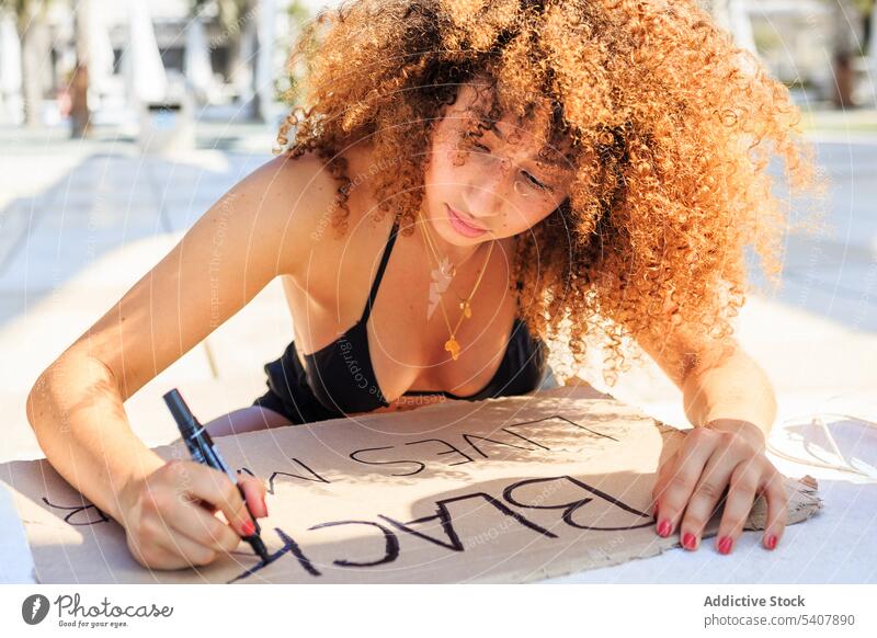 African American woman creating black lives matter poster protest demonstrate city marker pen writing no justice no peace activist female ethnic