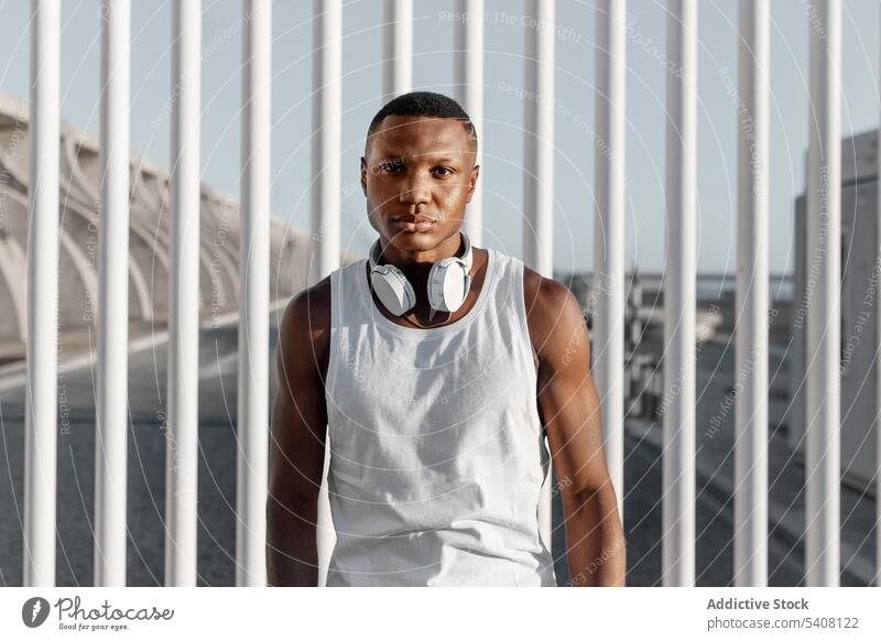 Confident black man standing near fence after training serious confident sport concentrate focus muscle strong sporty rest male muscular thoughtful sportsman