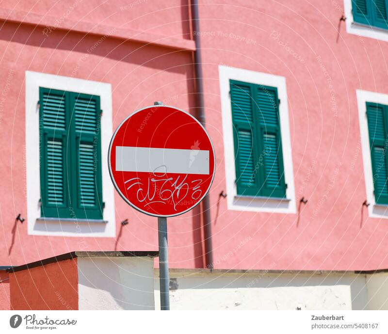 No through traffic sign in front of pink facade with green shutters passage forbidden interdiction Road sign Facade Pink Window Green lock Barred Transport