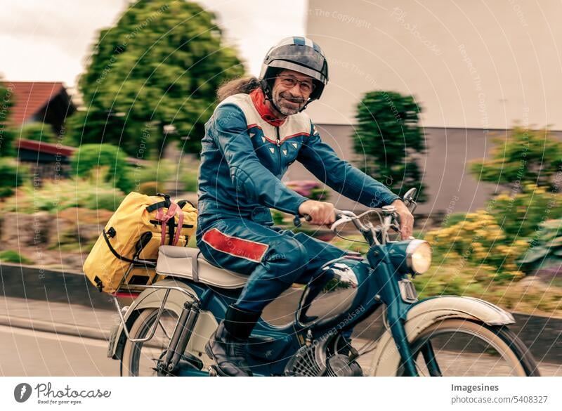Vintage moped riding is fun. Man with vintage helmet and vintage clothes in summer rides an old two-stroke Driving Helmet Retro garments Summer Old Leather